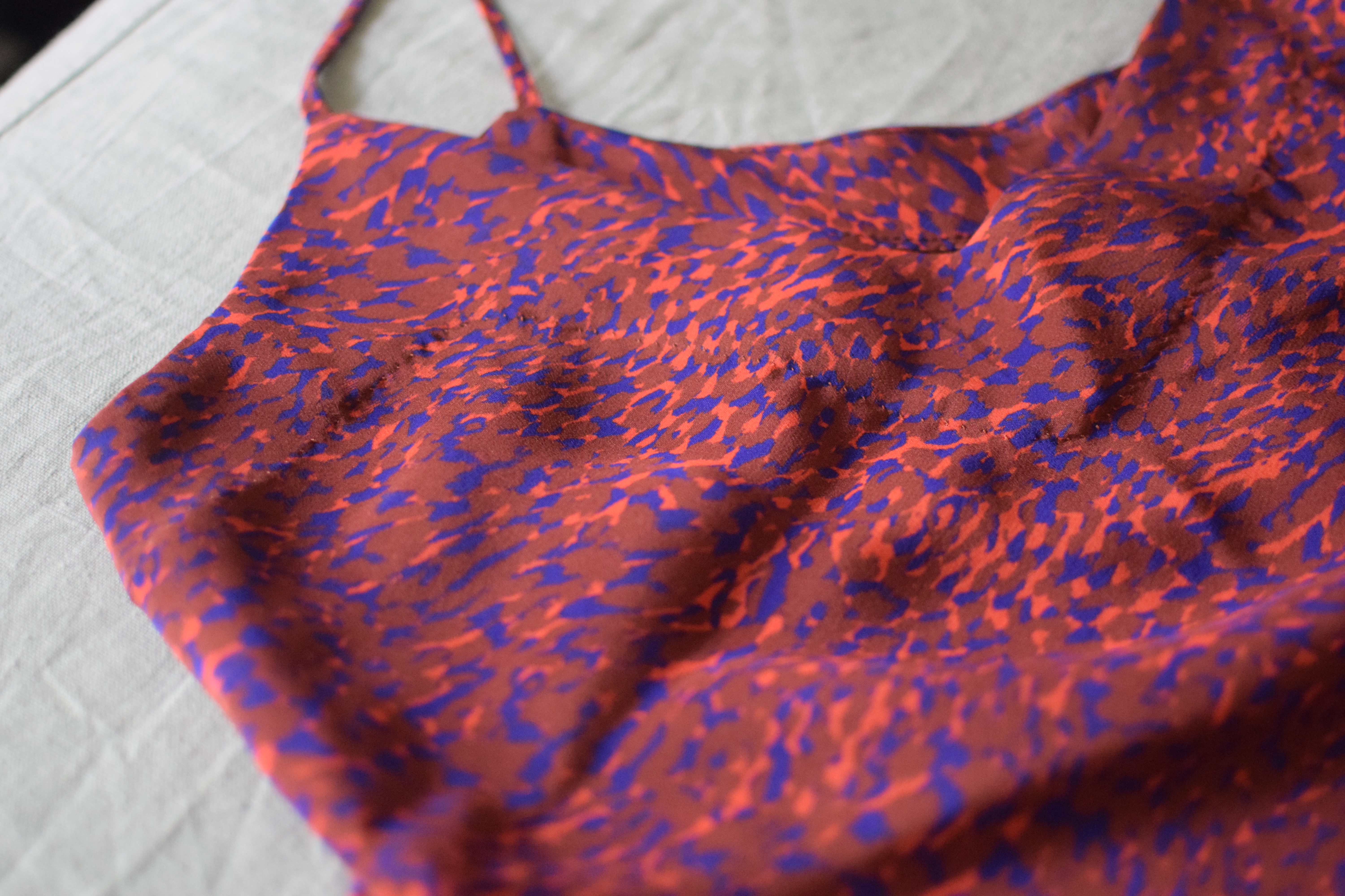 a laydown photo of a blue silk dress made from Tessuti Pattern's Sadie slipdress.