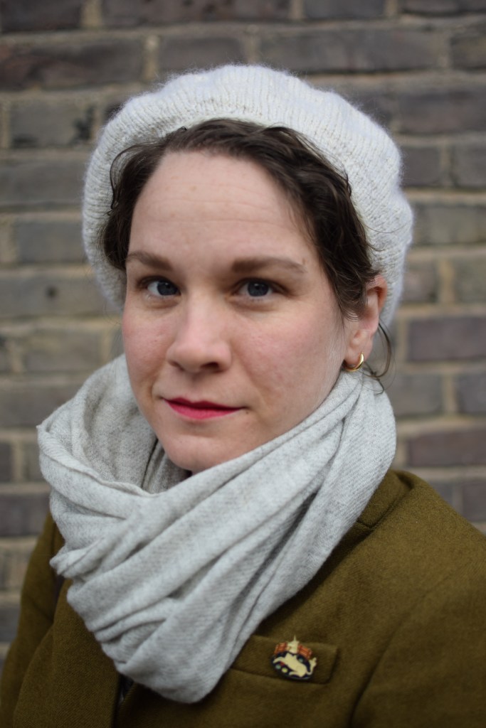 a woman shows off a new knitted beret.