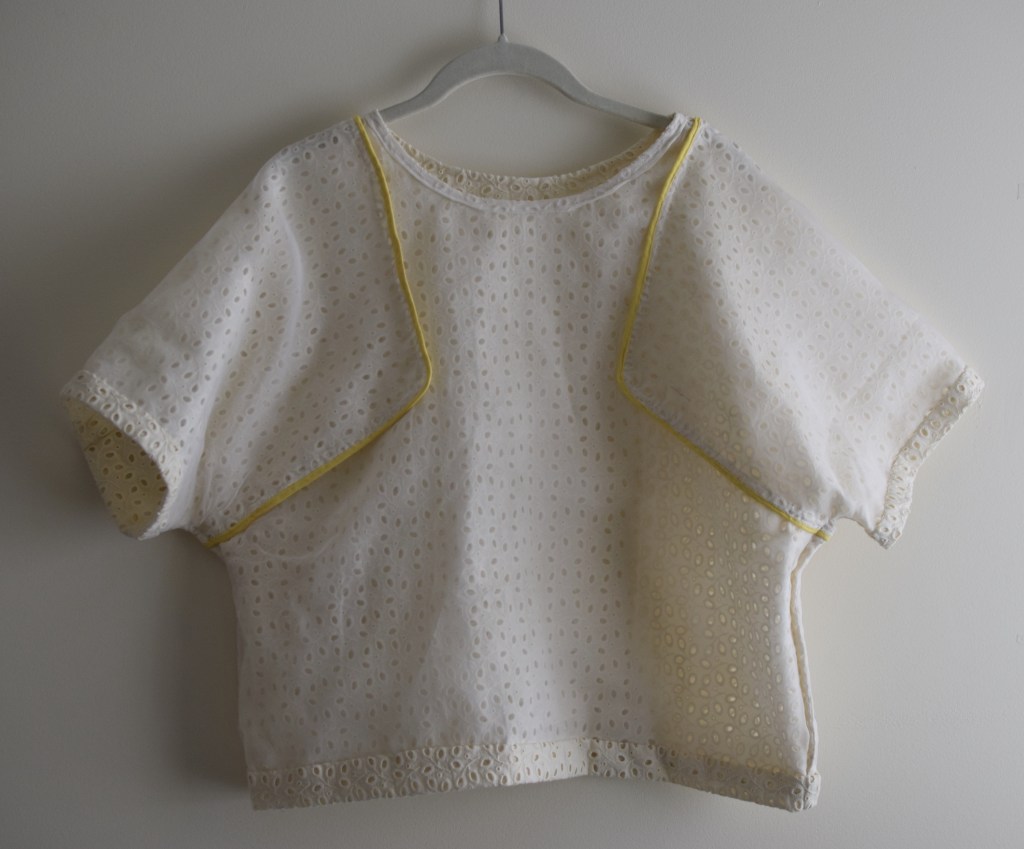 an inside-out eyelet top on a hanger.