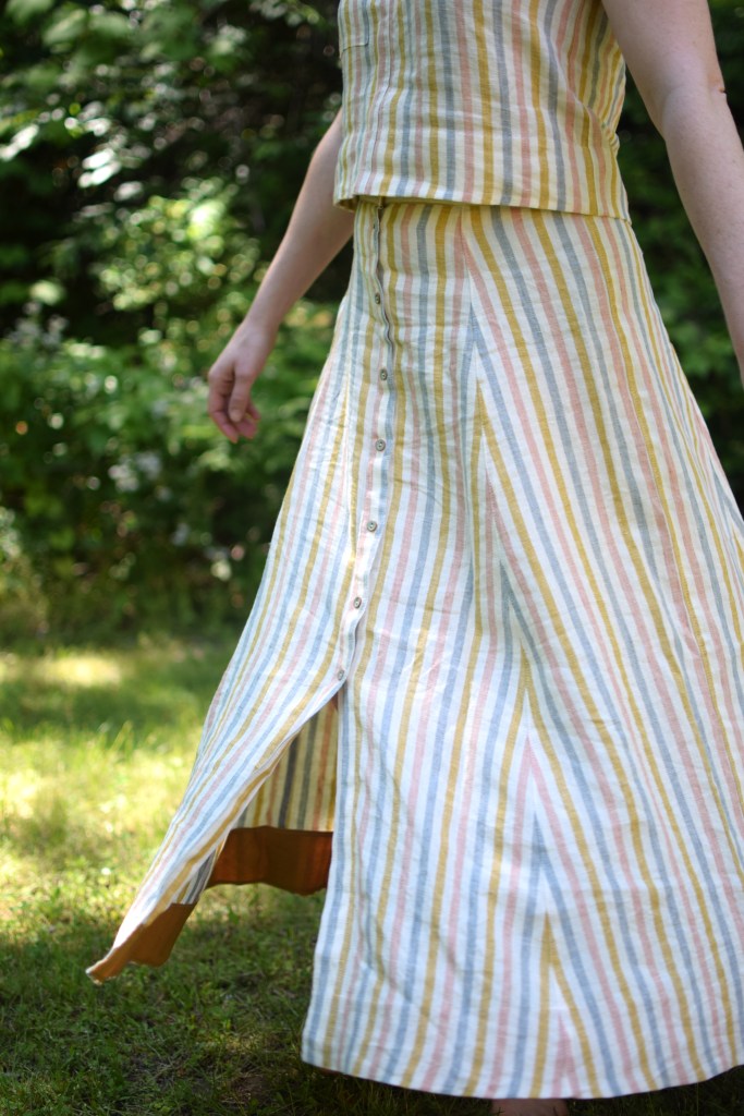 a woman twirls in a striped Wiksten tank top and Fumeterre skirt from Deer and Doe.