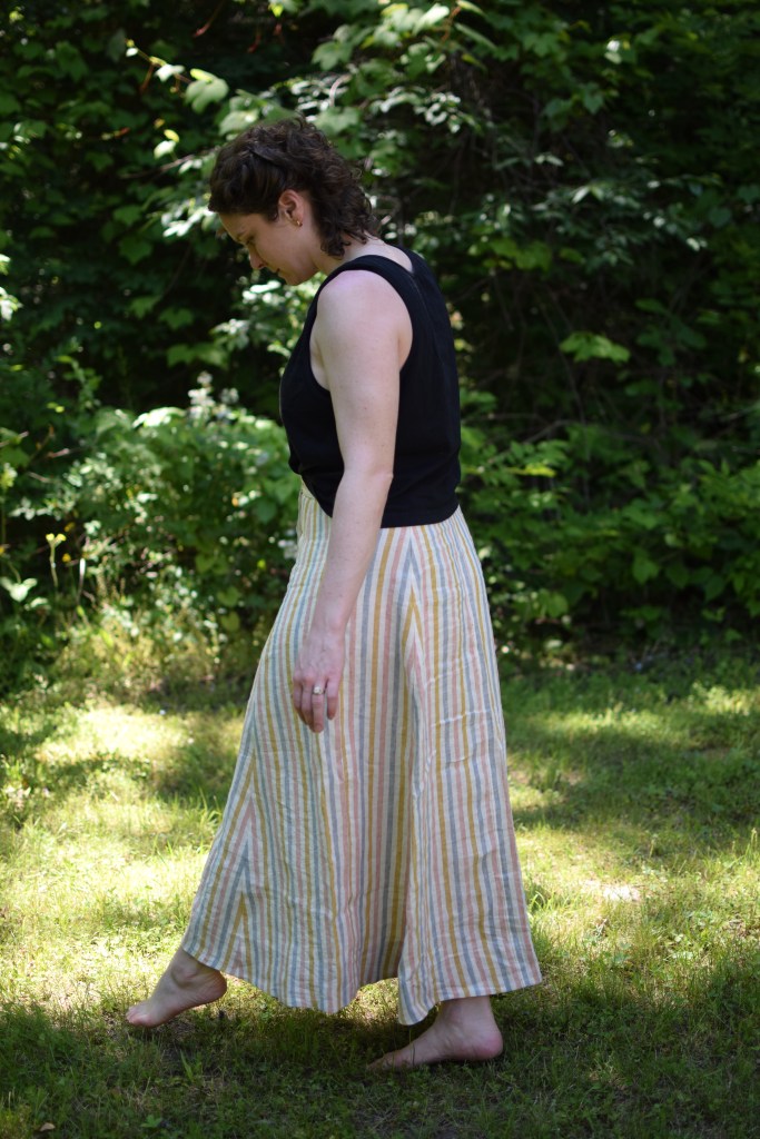 a woman stands outside wearing a long striped Fumeterre skirt from Deer and Doe.