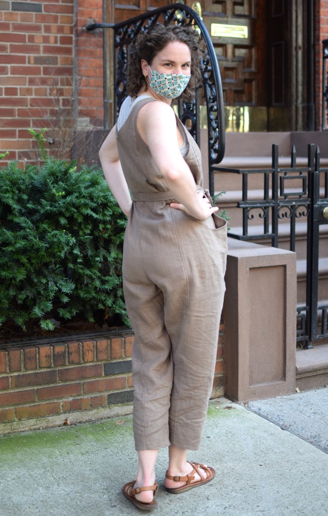 a woman stands on a sidewalk wearing a handmade Elizabeth Suzann clyde jumpsuit